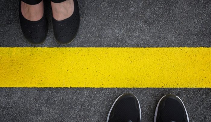 two sets of shoes on either side of a yellow line