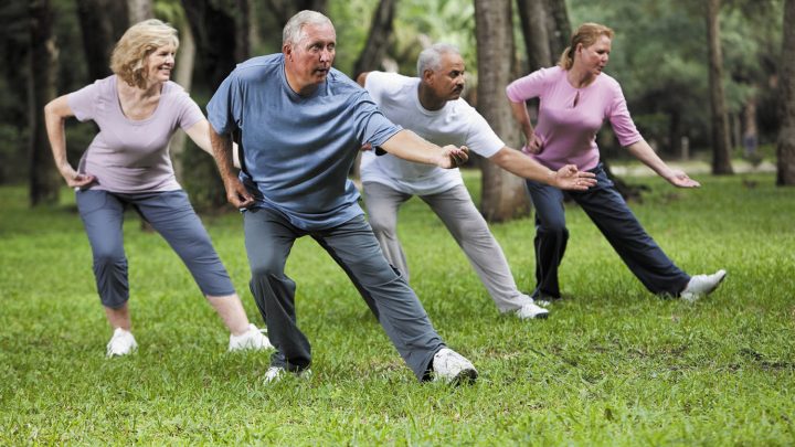 four people in park participating in tai chi