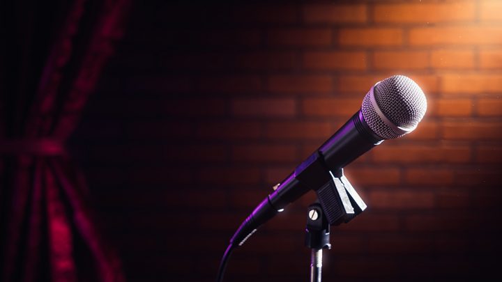 microphone on stand in front of brick wall