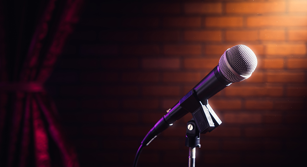 microphone on stand in front of brick wall