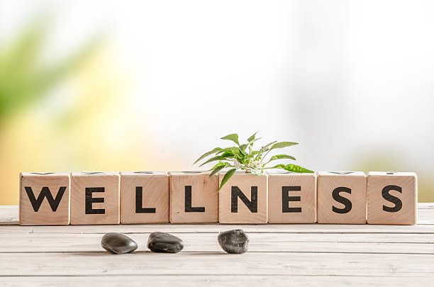 the word "wellness" spelled with scrabble tiles
